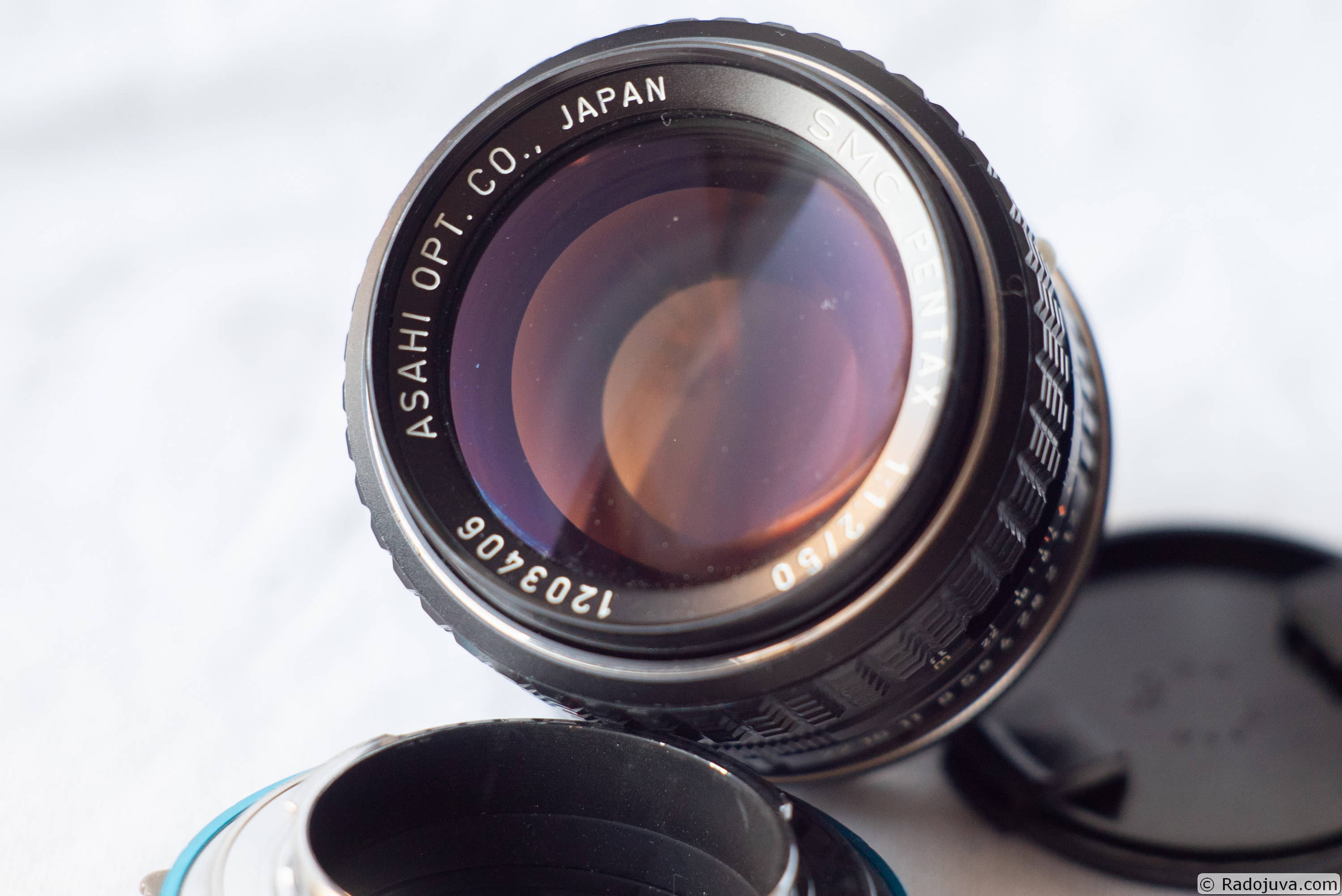 The amber-violet glare of the Pentax 50/1.2 lenses is due to the presence of a multilayer antireflection coating on the objective lenses.